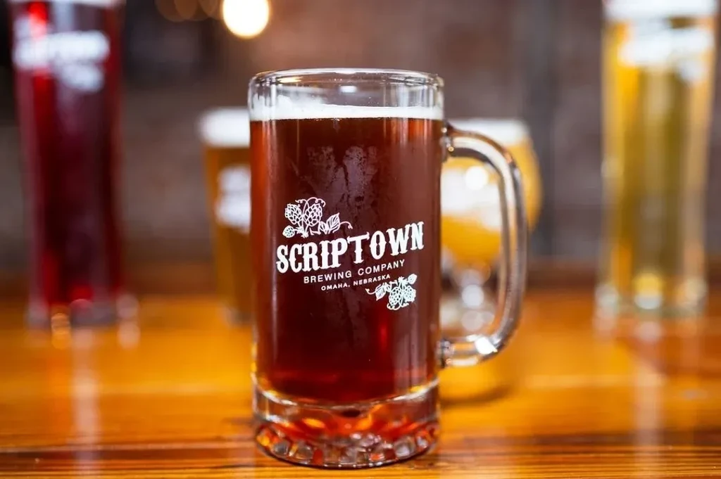 SCRIPTOWN BREWING dark beer mug with condensation on a wooden bar.