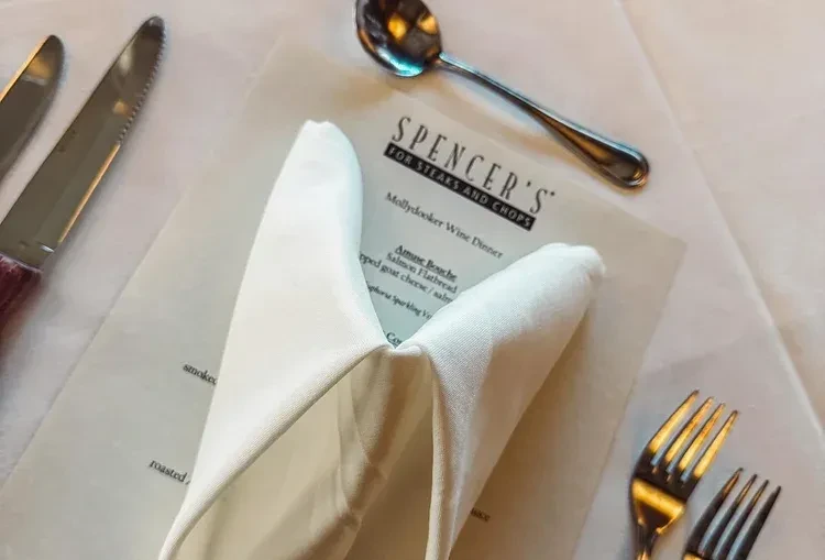 Restaurant table with folded napkin and Spencer's Wine Dinner menu.