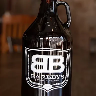 Dark brown glass growler with handle and 'BARLEYS' label.