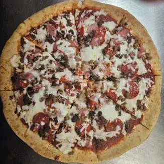 Sliced, thick-crust pizza with cheese, pepperoni, and crumbled meat.