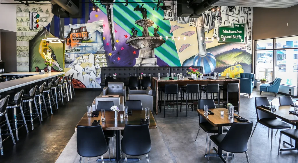 Vibrant modern restaurant interior with diverse seating and colorful mural.