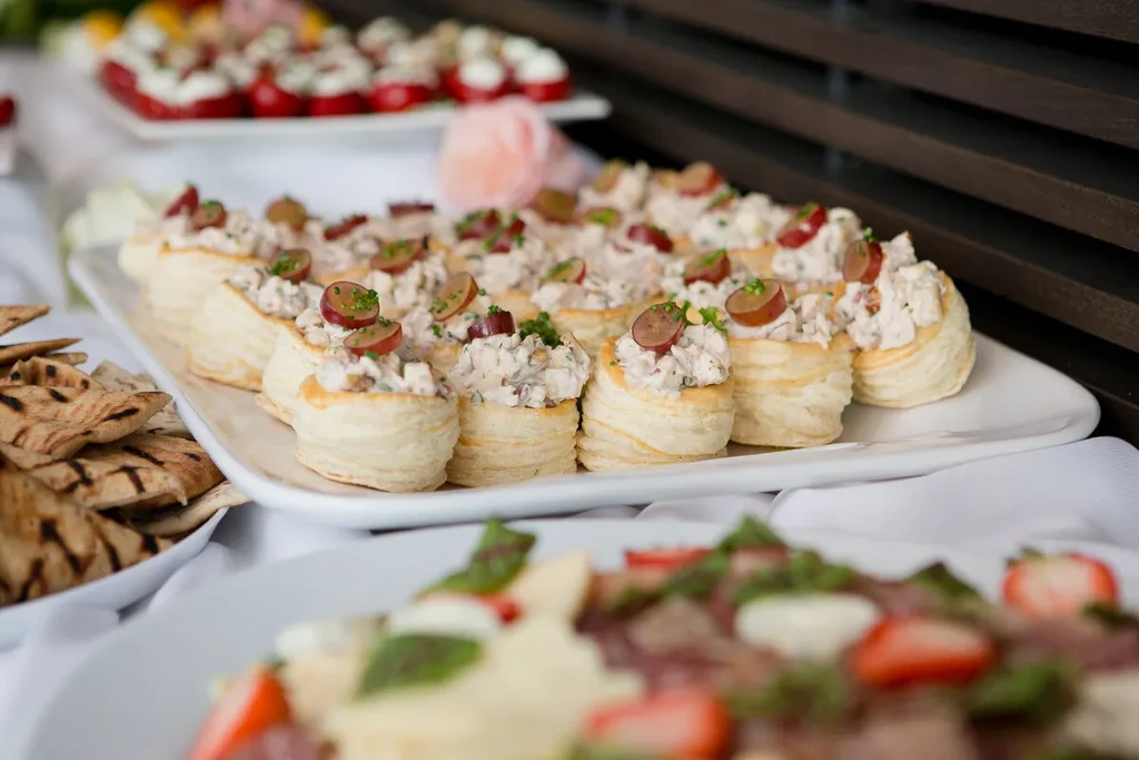 Puff pastry vol-au-vents with creamy salad, grapes, and herbs on a platter.