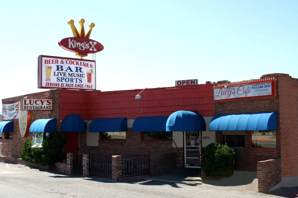 Exterior of Lucy's Restaurant and King's X bar with multiple signs.
