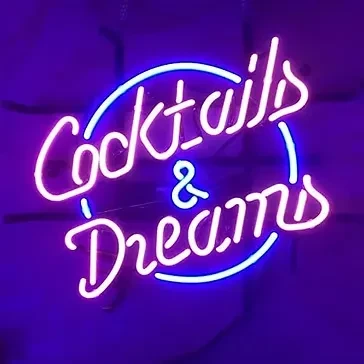 White-blue neon sign reads 'Cocktails & Dreams' in cursive against a dark background.