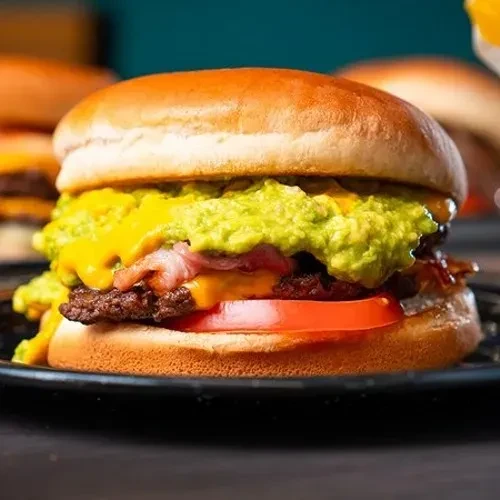 Hamburger with beef patty, melted cheese, bacon, avocado, tomato.