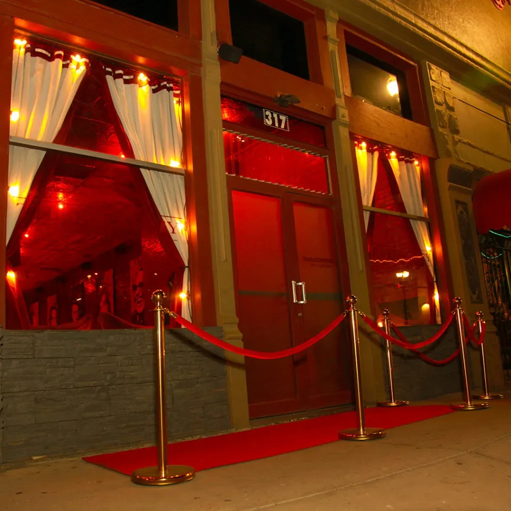 Red carpet leads to building 317 with glowing red windows at night.
