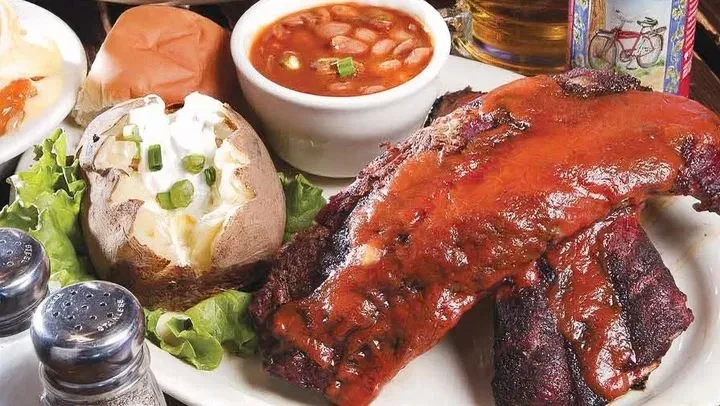 BBQ ribs, loaded baked potato, baked beans, and sides.