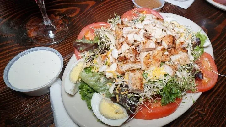Chicken salad with grilled chicken, eggs, tomatoes, almonds, cheese, sprouts.
