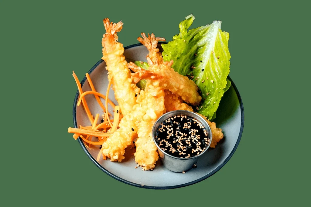 Plate of four tempura shrimp with carrots, lettuce, and dipping sauce.
