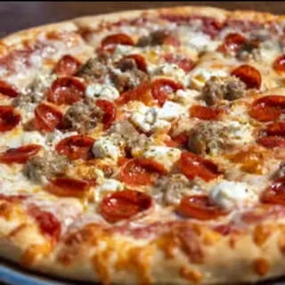 Overhead of freshly baked pizza with pepperoni, sausage, and multiple cheeses.