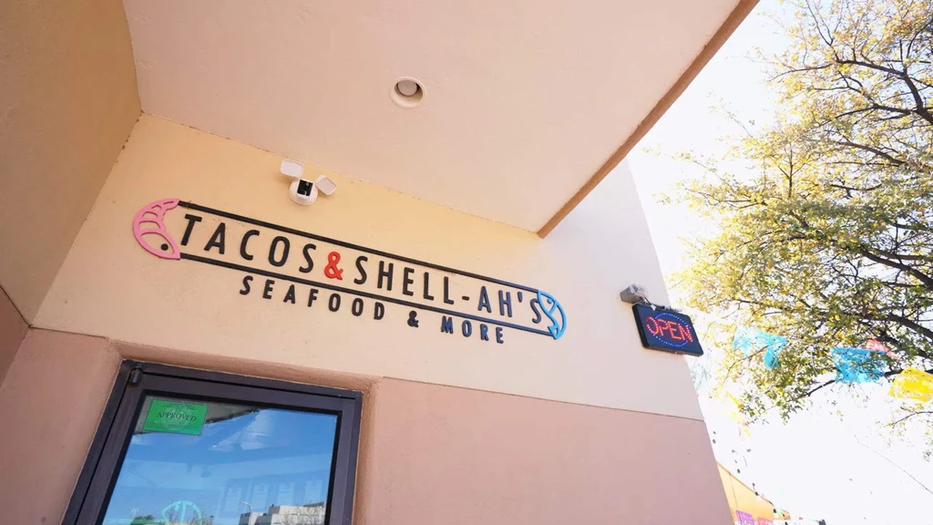 Restaurant TACOS & SHELL-AH'S exterior sign with shrimp, fish, and OPEN sign.