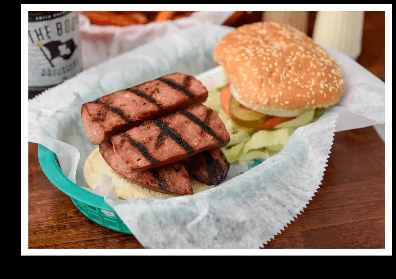 Char-marked grilled sausage slices and a burger in a blue basket.