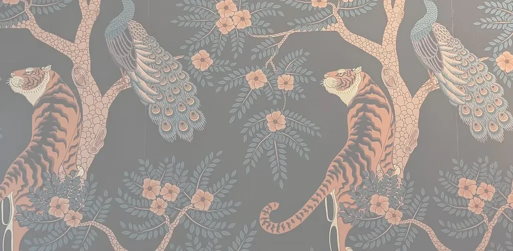 Repeating wallpaper pattern of tigers and peacocks in a forest.