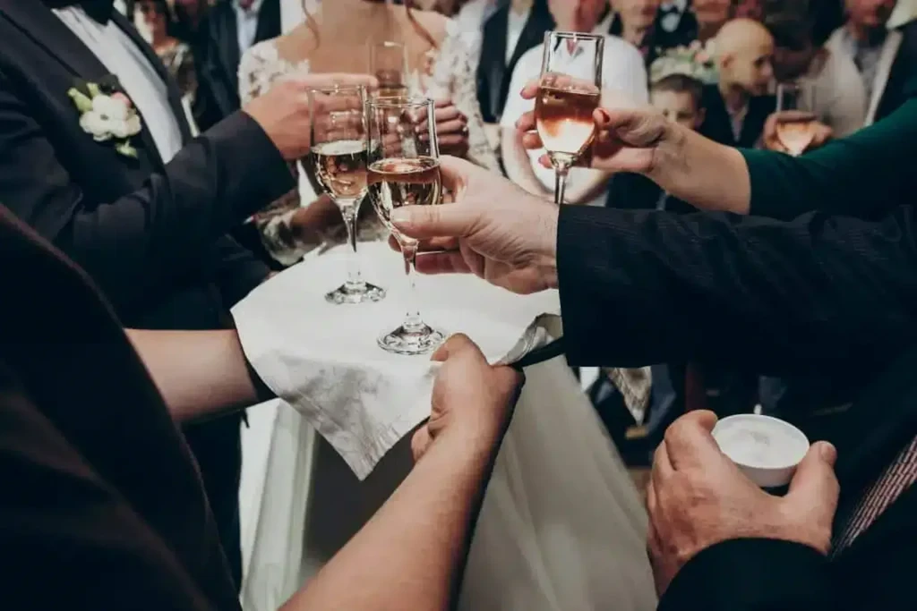 Several hands holding champagne flutes, toasting at a wedding reception.