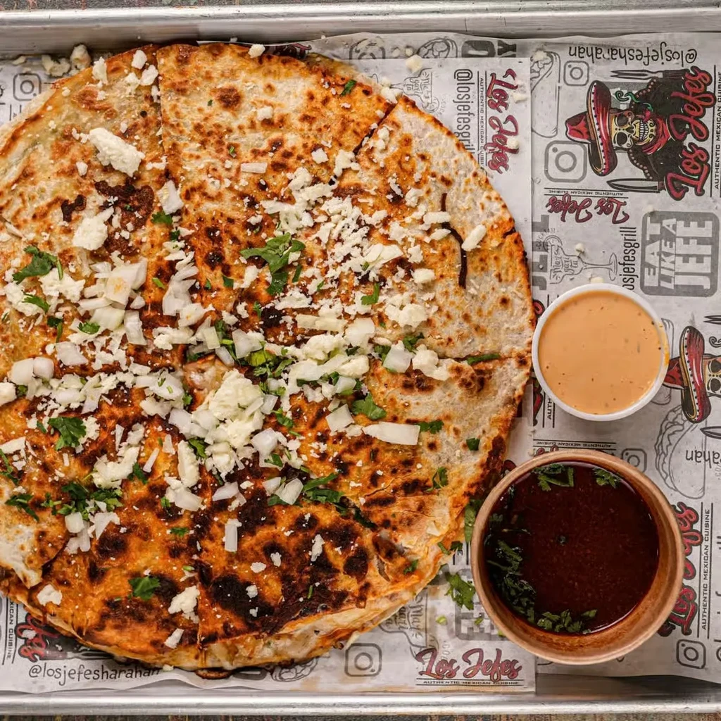 Crispy Mexican flatbread topped with cheese, onions, herbs, and sauces.