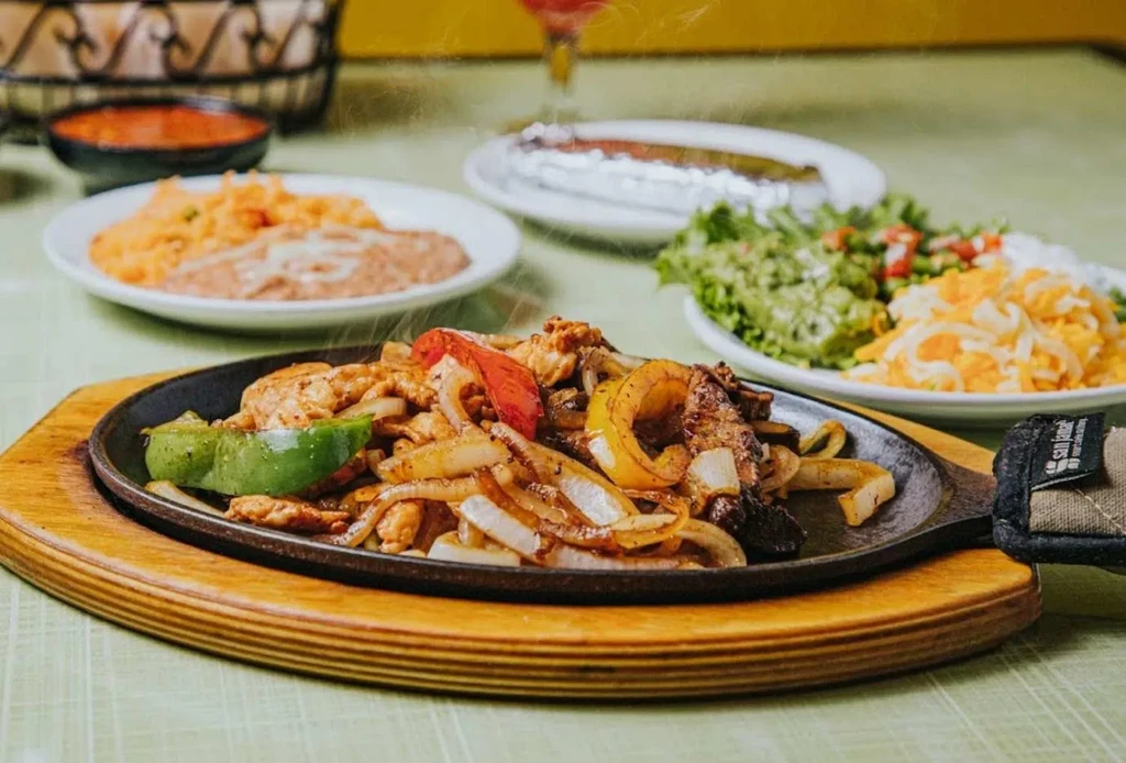 Sizzling chicken or steak fajitas generously topped with peppers and onions.