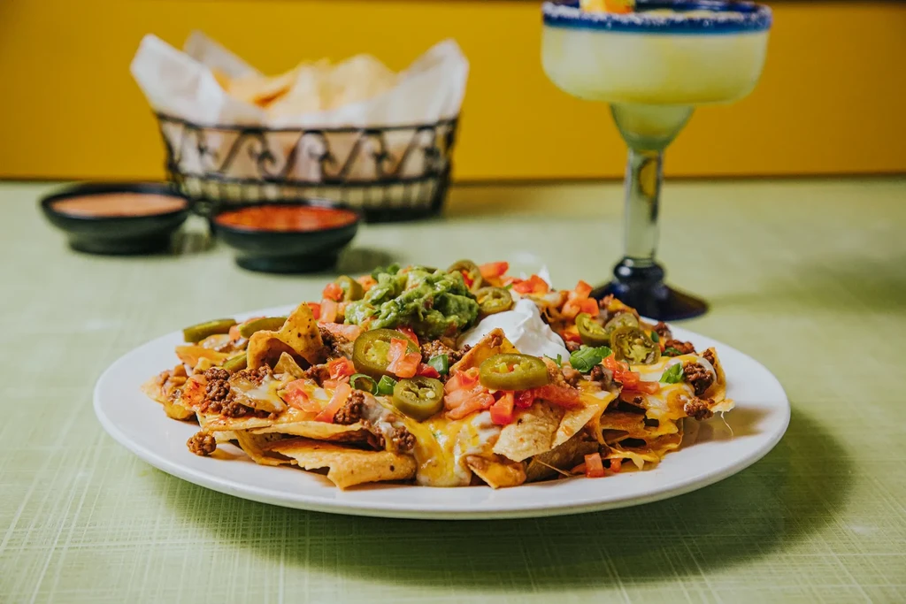 Fully loaded nachos with cheese, meat, tomatoes, jalapeños, sour cream, guacamole.