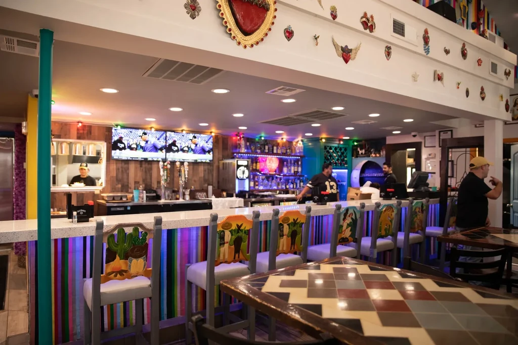 Lively, colorful Mexican-themed restaurant interior with a vibrant bar area.