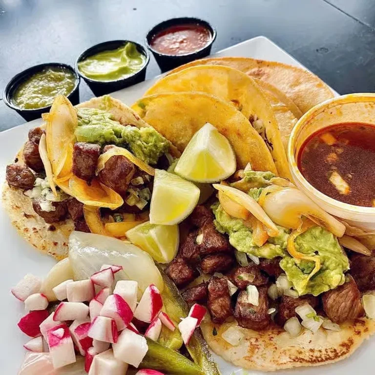Street tacos with meat, guacamole, lime, radishes, salsas, and consommé.