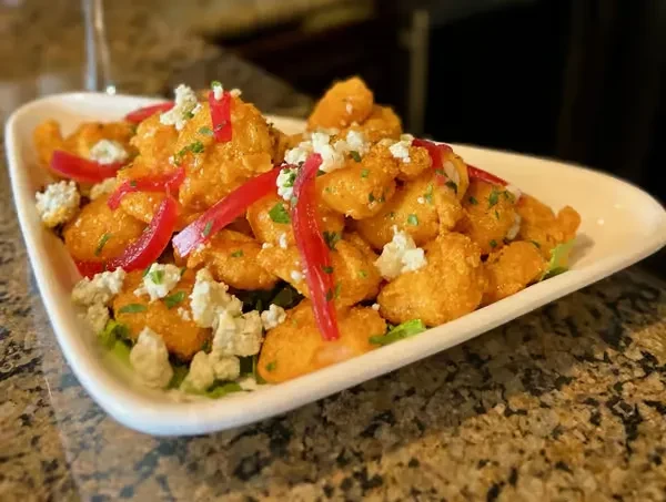 Orange-sauced fried shrimp or chicken with red strips and blue cheese.
