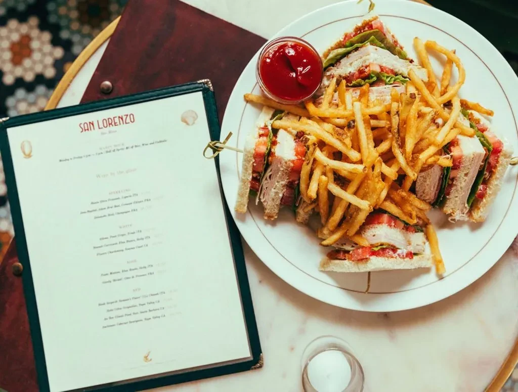 Overhead view of club sandwich, fries, ketchup, and San Lorenzo menu.