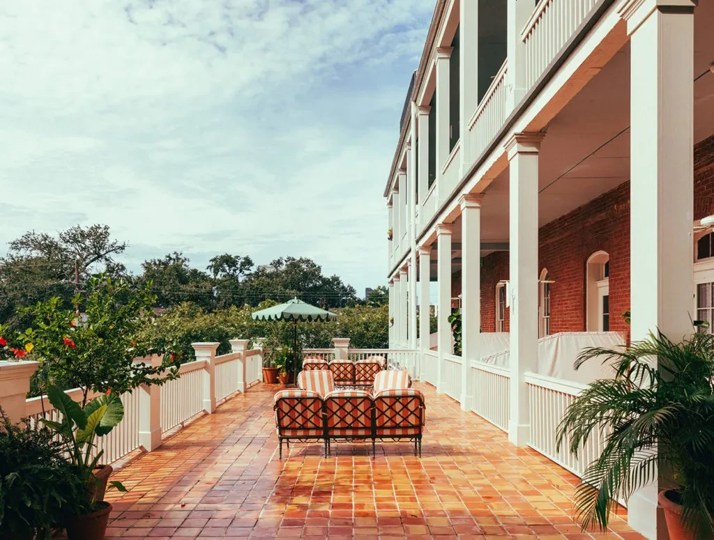Spacious multi-story building patio with terracotta tiles and outdoor seating.
