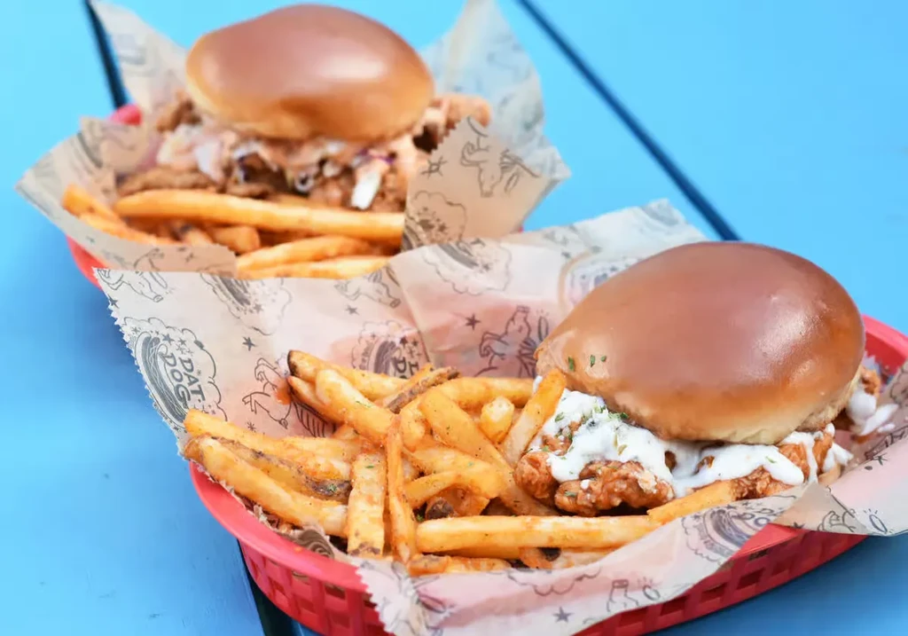 Two crispy chicken sandwiches and fries in DAT DOG branded baskets.