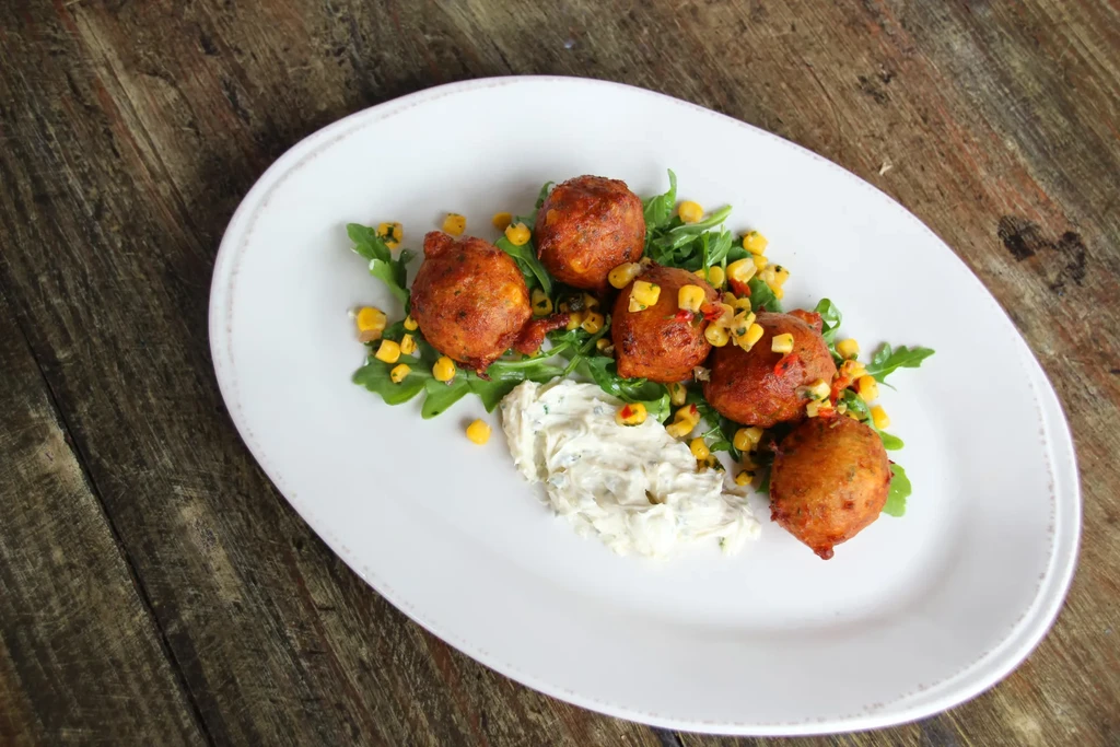 Five fried fritters on greens with corn relish and herb sauce.