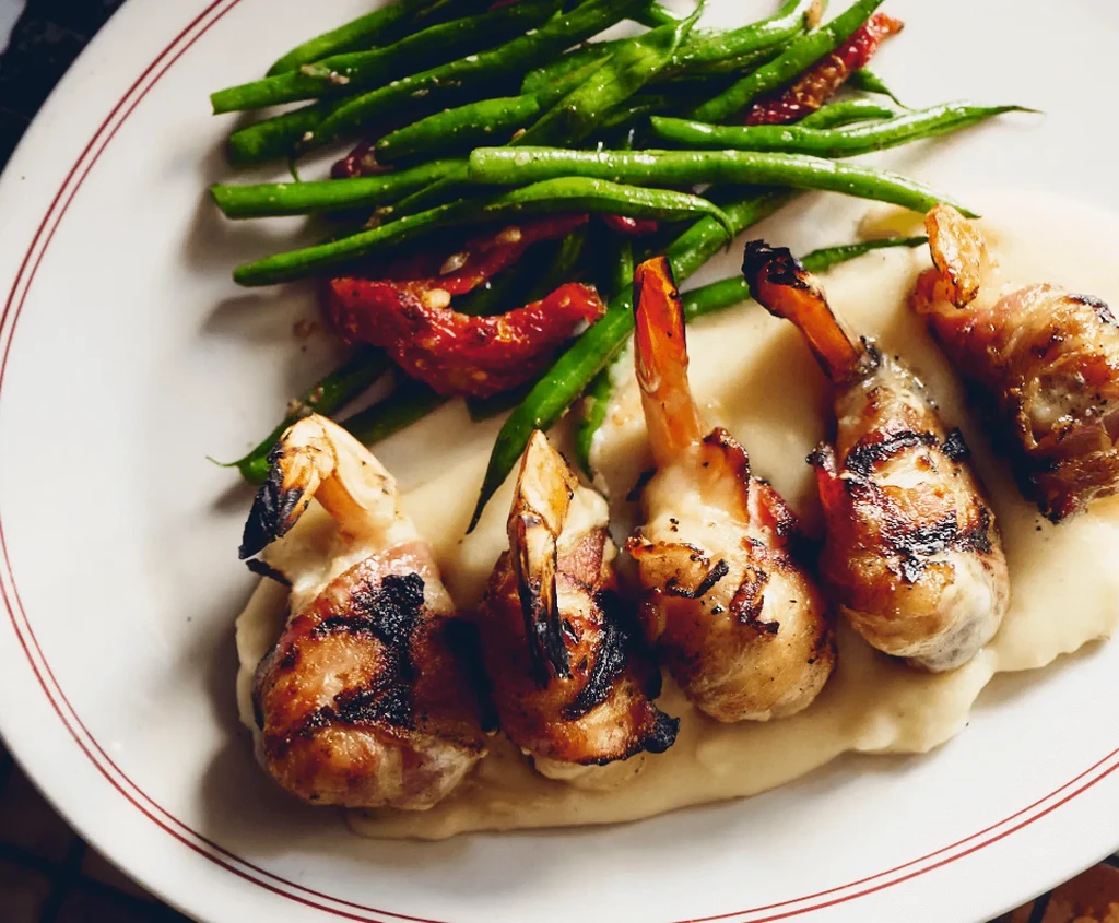 Grilled bacon-wrapped shrimp, green beans, sun-dried tomatoes, creamy base.