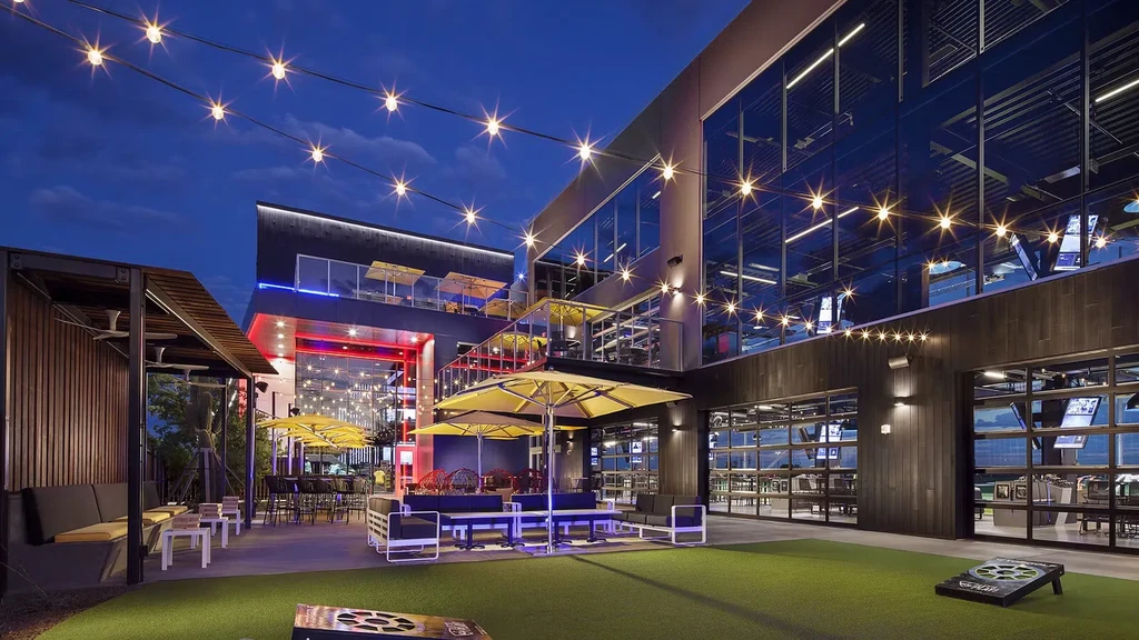 Contemporary restaurant complex with multi-level illuminated outdoor patio at night.