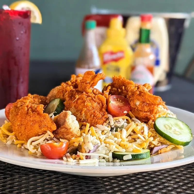 Crispy fried chicken salad with mixed greens, cheese, and vegetables.