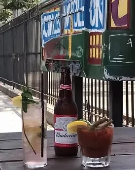 Cocktail, beer, and Bloody Mary on an outdoor table.
