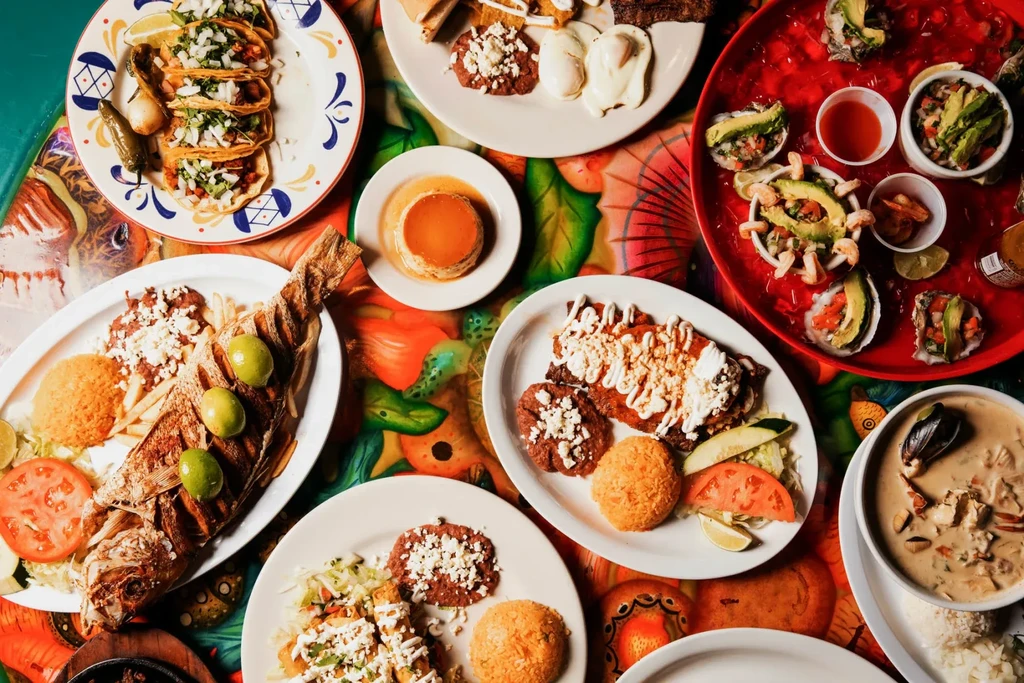Vibrant spread of Mexican tacos, fried fish, flan, and ceviche.