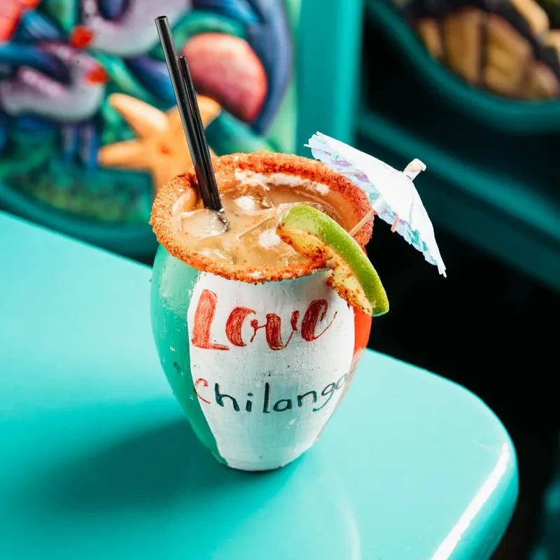 Iced drink in Mexican flag-striped mug with chili salt rim.