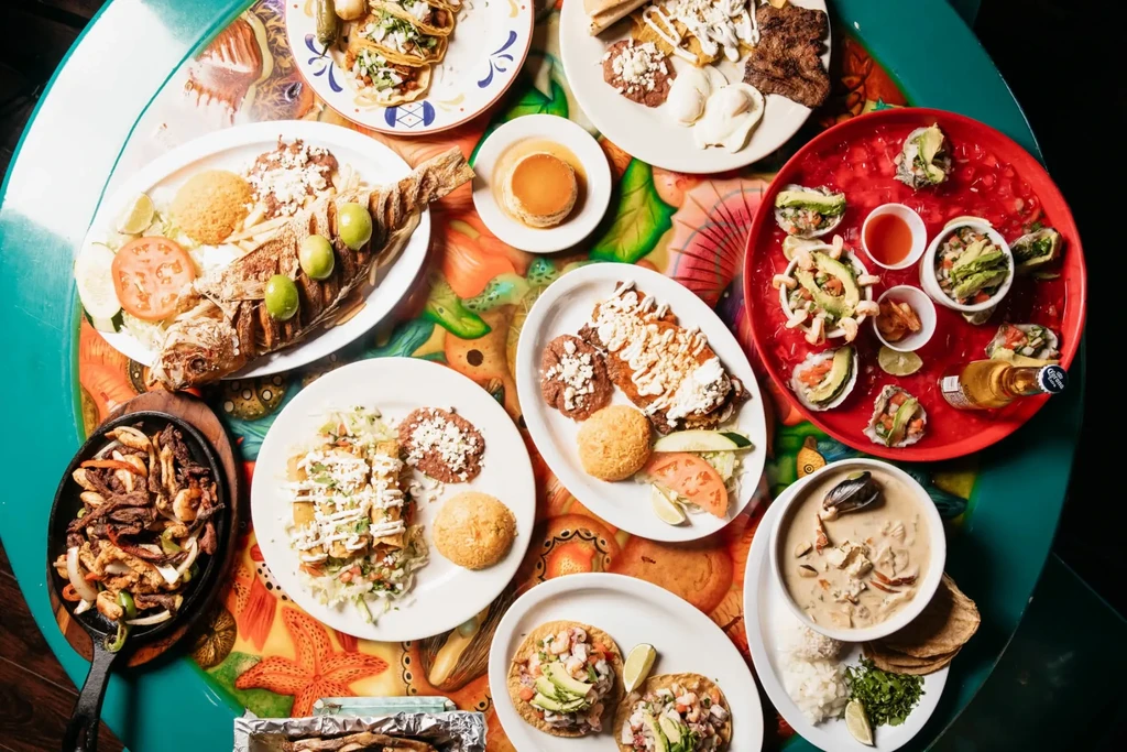 Overhead view of a colorful table with Mexican food and sea creature mural.