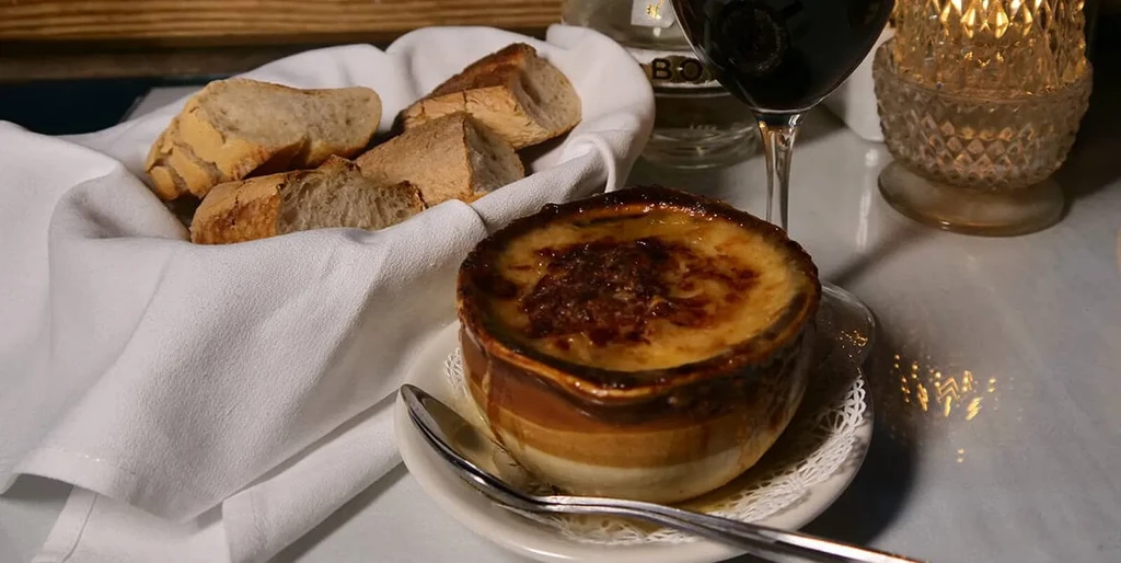 Bubbling French onion soup with melted cheese, bread, and red wine.