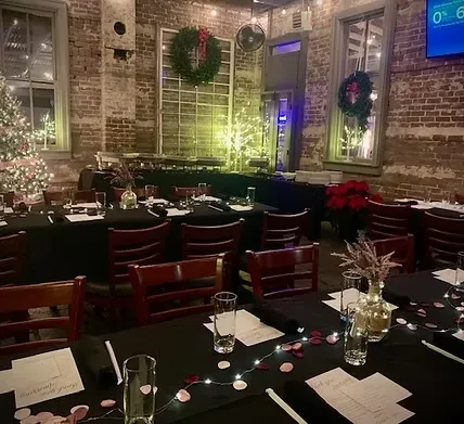 Cozy rustic restaurant interior with Christmas decorations and empty tables.