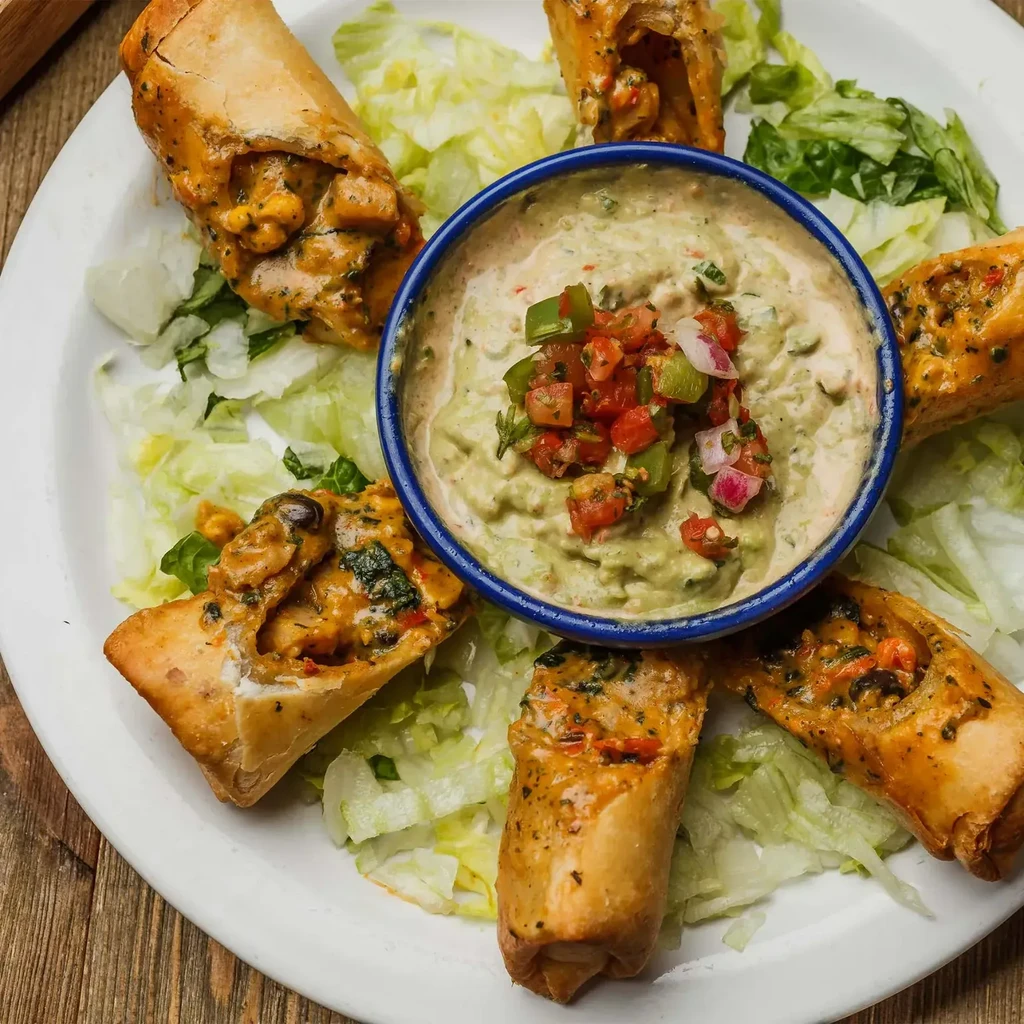 Golden-brown fried taquitos with chicken, lettuce, guacamole, and pico de gallo.