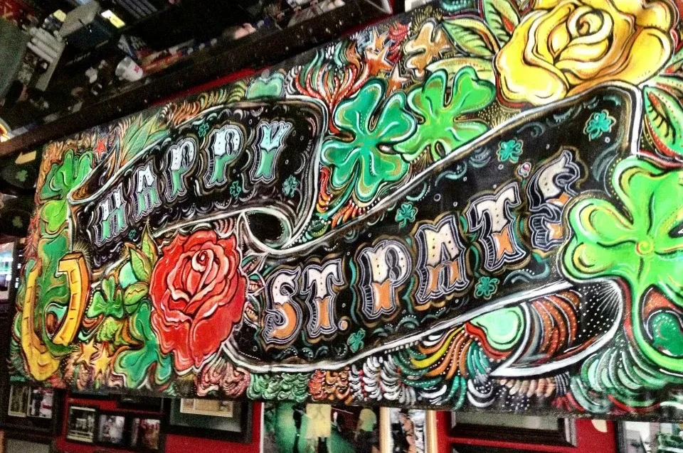 Ornate, colorful mural saying "HAPPY ST. PAT'S" with roses and shamrocks.