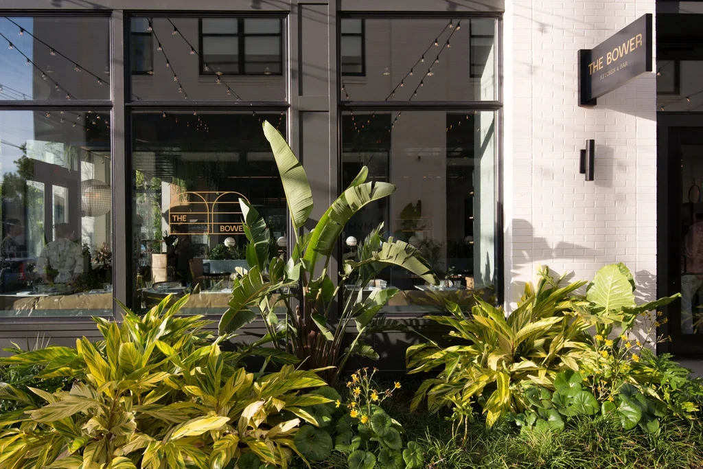 Exterior of The Bower Kitchen & Bar with lush tropical garden.