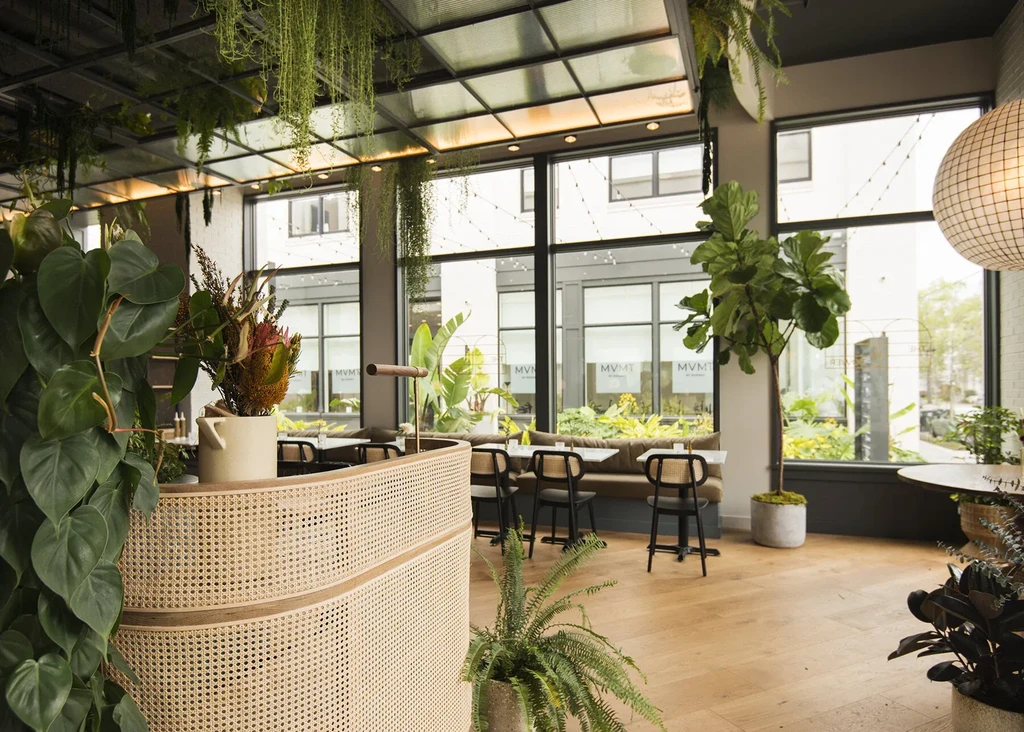 Modern botanical-themed restaurant with abundant greenery and natural light.