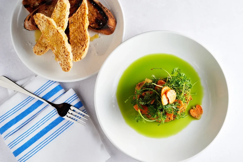 Two dishes: green liquid with herbs, and golden-brown toasted bread.