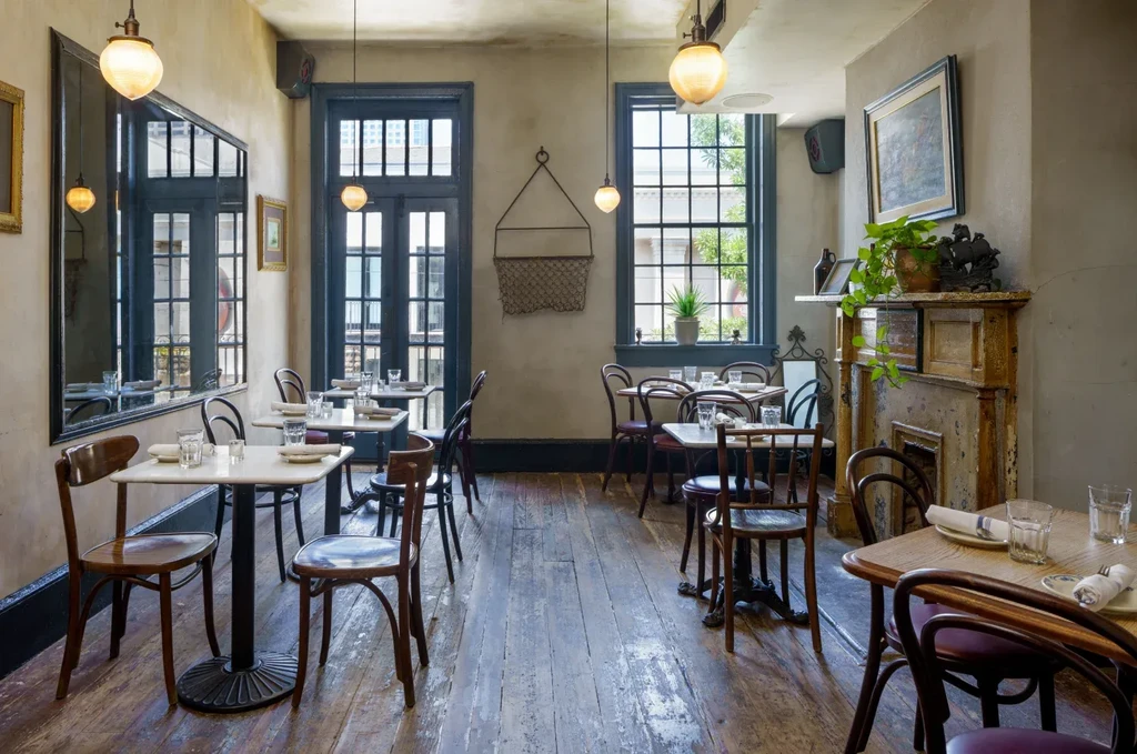 Rustic restaurant interior with set tables and vintage decor.