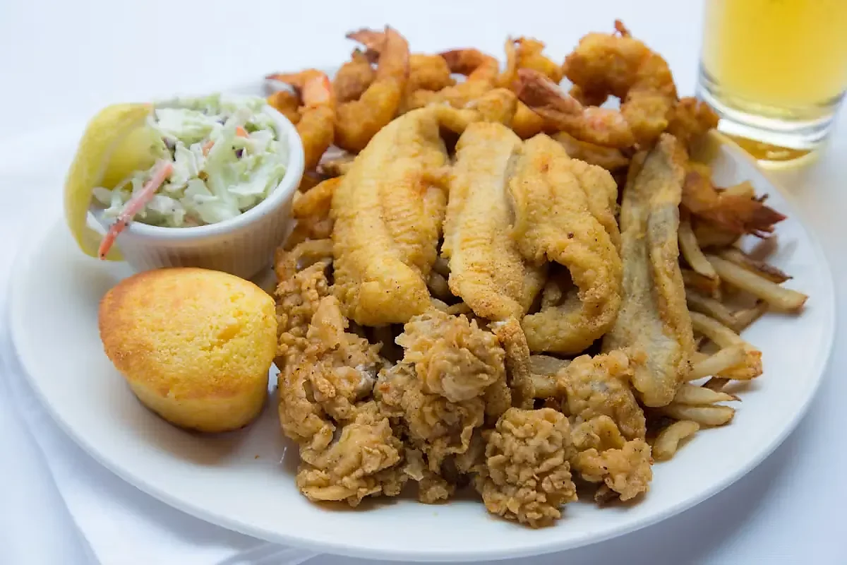 Fried seafood platter with catfish, shrimp, oysters, fries, slaw, cornbread