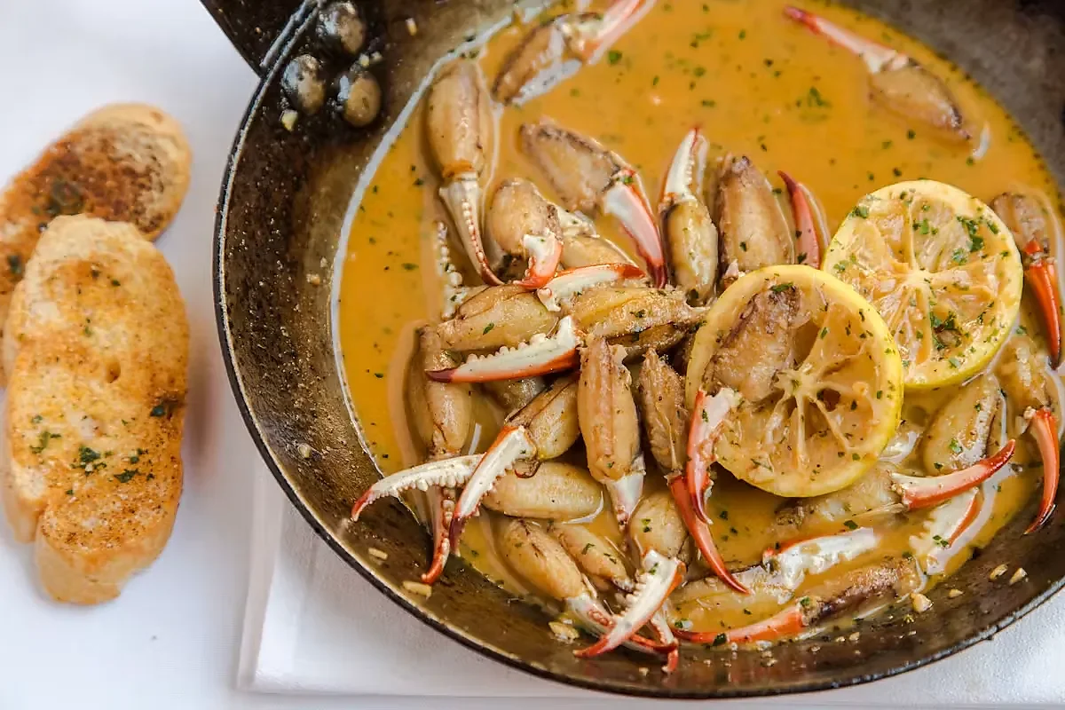 Crab claws in bordelaise butter sauce with lemon and garlic bread