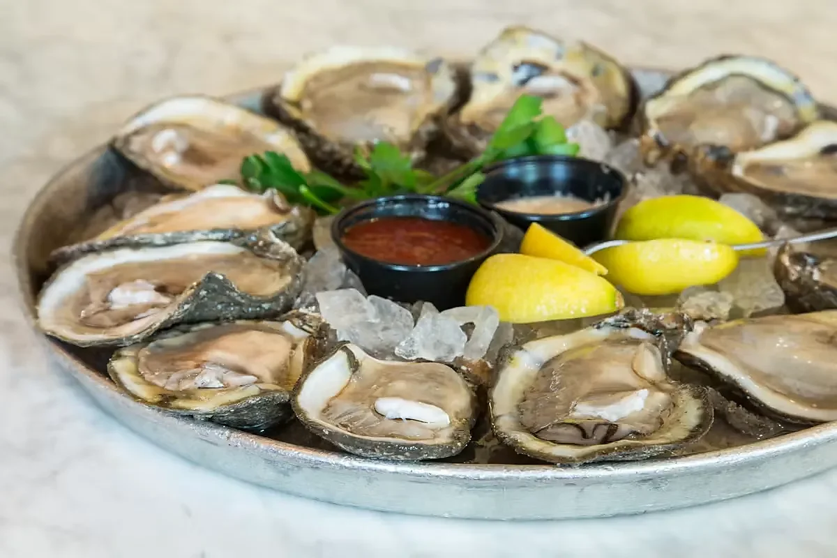 Dozen raw oysters on the half shell with lemon and sauces