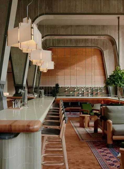 Modern restaurant interior showcasing a green-tiled bar and lounge seating.