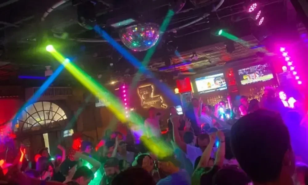 Colorful lights, disco ball, and dancing crowd at a Louisiana nightclub.