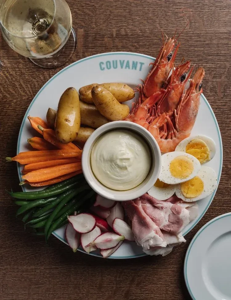 Overhead platter of prawns, vegetables, eggs, ham, and sauce.
