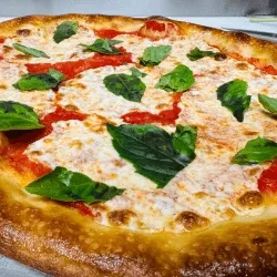 Close-up of a Neapolitan pizza with tomato sauce, mozzarella, and basil.